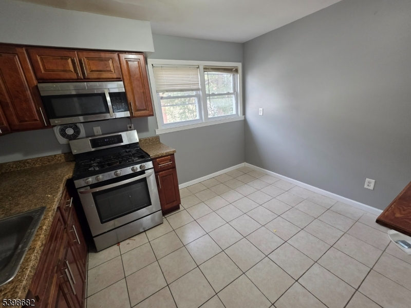 97 Goodwin Avenue Newark, NJ 07112 - Photo 6 of 20 a kitchen with granite countertop a sink stove and microwave