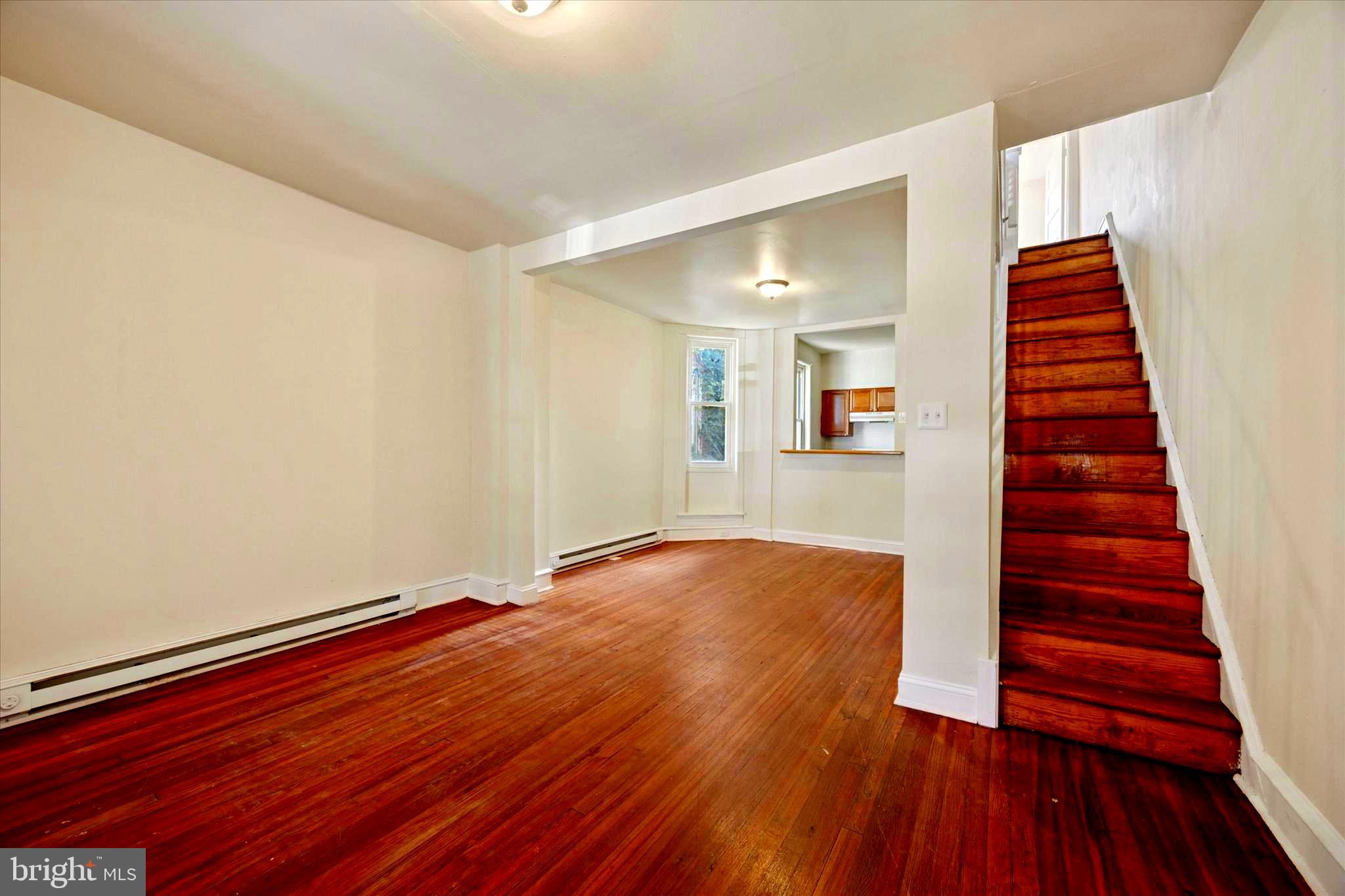 1549 North Wanamaker Street Philadelphia, PA 19131 - Photo 3 of 15 a view of an empty room with wooden floor and stairs