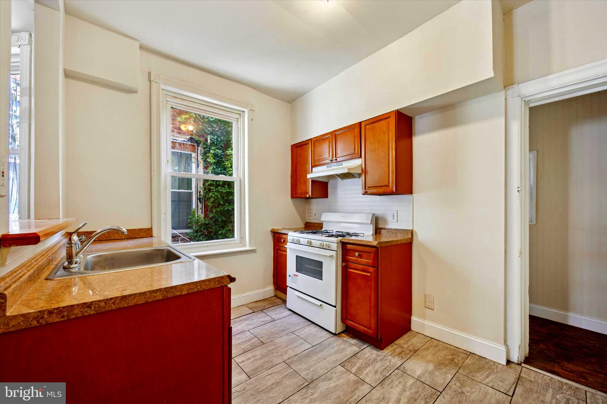 1549 North Wanamaker Street Philadelphia, PA 19131 - Photo 6 of 15 a kitchen with stainless steel appliances granite countertop a stove a sink and a refrigerator