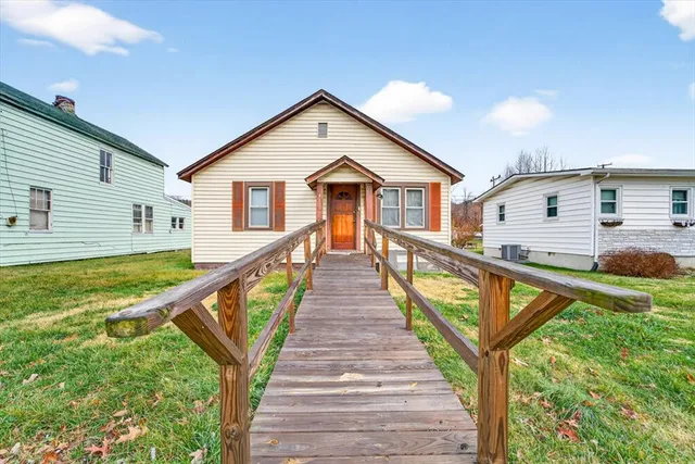 a view of a house with wooden stairs and a small yard