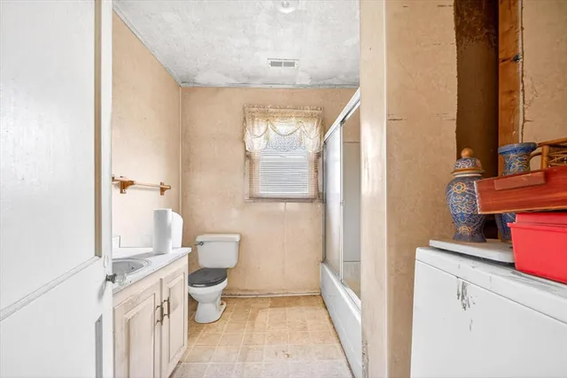 a bathroom with a granite countertop sink a toilet and a mirror