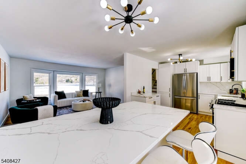 22 Glen Road Bridgewater, NJ 08805 - Photo 23 of 48 a kitchen with stainless steel appliances kitchen island granite countertop a refrigerator a sink dishwasher a dining table and chairs with wooden floor