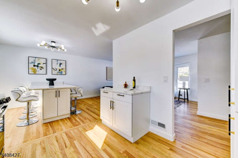 22 Glen Road Bridgewater, NJ 08805 - Photo 28 of 48 a view of a kitchen with kitchen island a sink wooden floor and a living room
