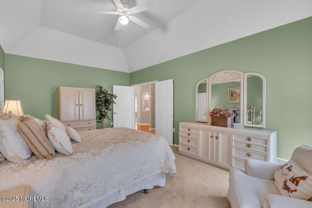 93 Pebble Beach Boulevard Jackson, NJ 08527 - Photo 16 of 47 a spacious bedroom with a bed and a chandelier