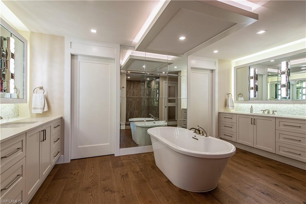 13915 Old Coast Road, Unit 602 Naples, FL 34110 - Photo 12 of 25 a spacious bathroom with a double vanity sink a mirror and a bathtub