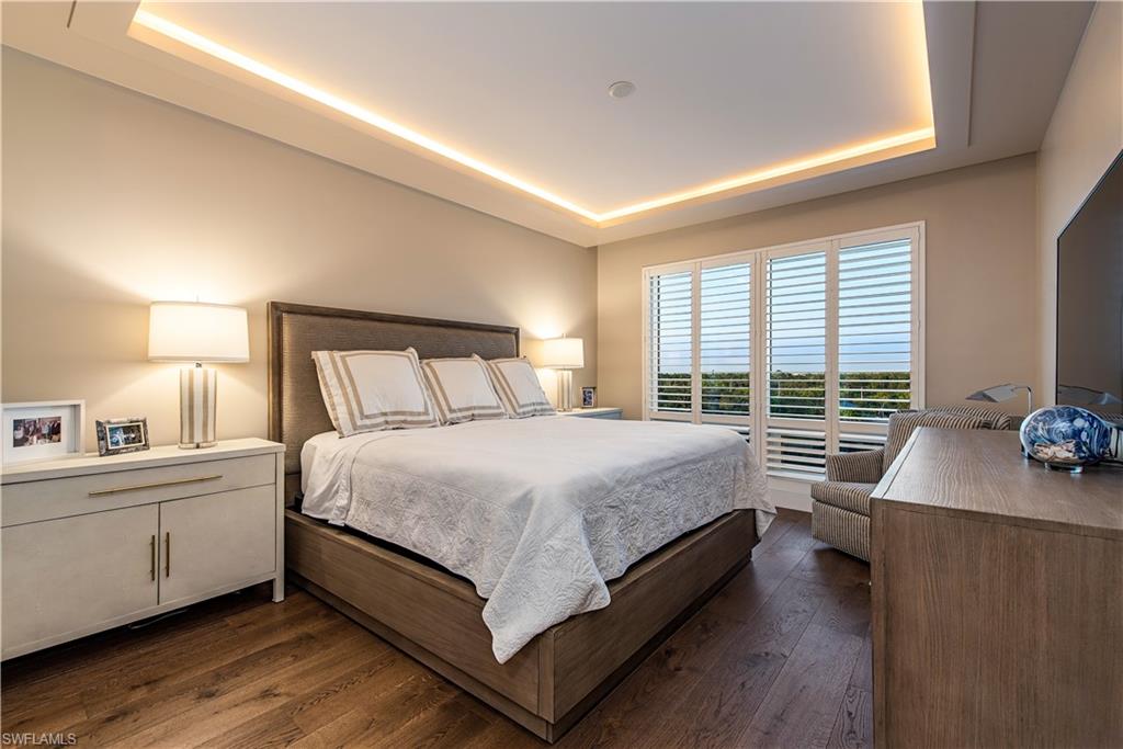 13915 Old Coast Road, Unit 602 Naples, FL 34110 - Photo 15 of 25 a bedroom with a large bed and a desk