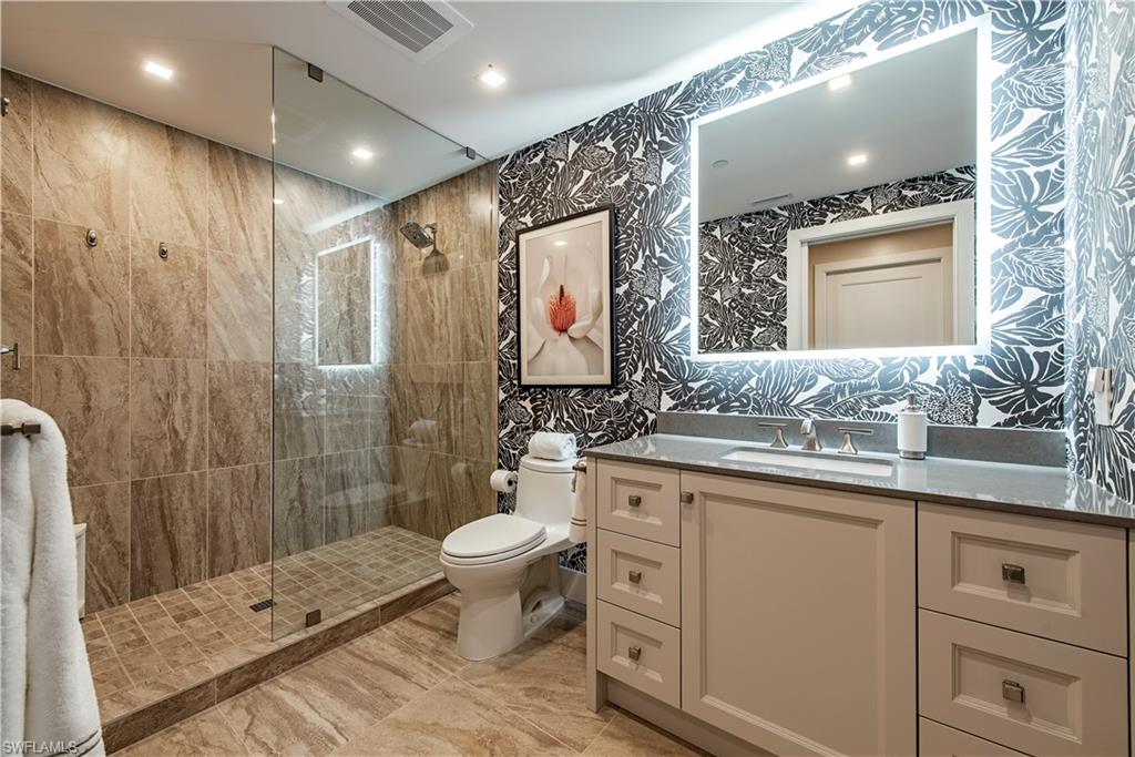 13915 Old Coast Road, Unit 602 Naples, FL 34110 - Photo 16 of 25 a spacious bathroom with a granite countertop sink toilet and shower