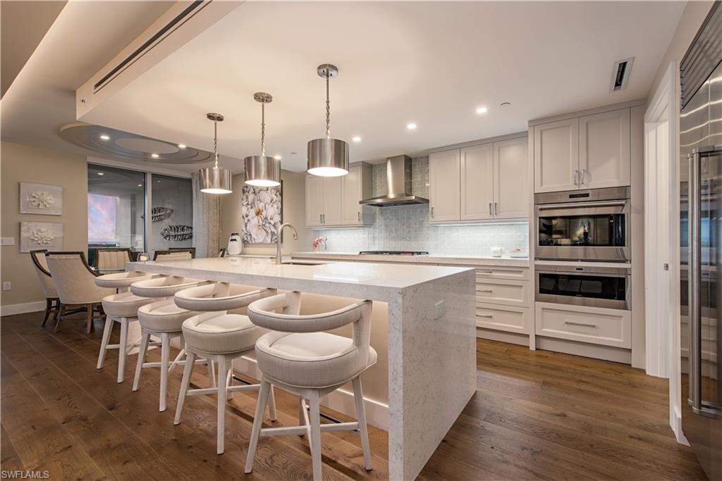 13915 Old Coast Road, Unit 602 Naples, FL 34110 - Photo 5 of 25 a large kitchen with kitchen island cabinets and stainless steel appliances