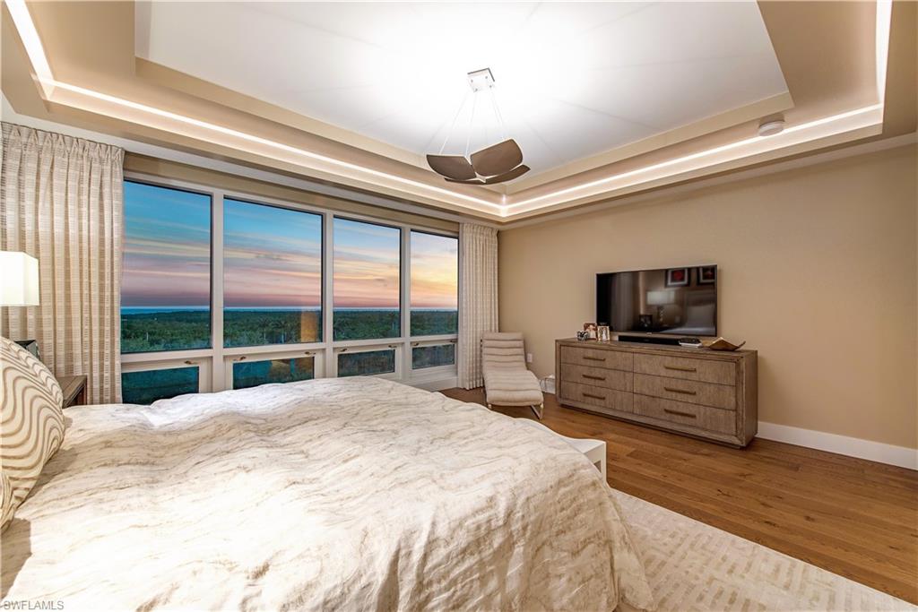 13915 Old Coast Road, Unit 602 Naples, FL 34110 - Photo 9 of 25 a bedroom with furniture and a flat screen tv