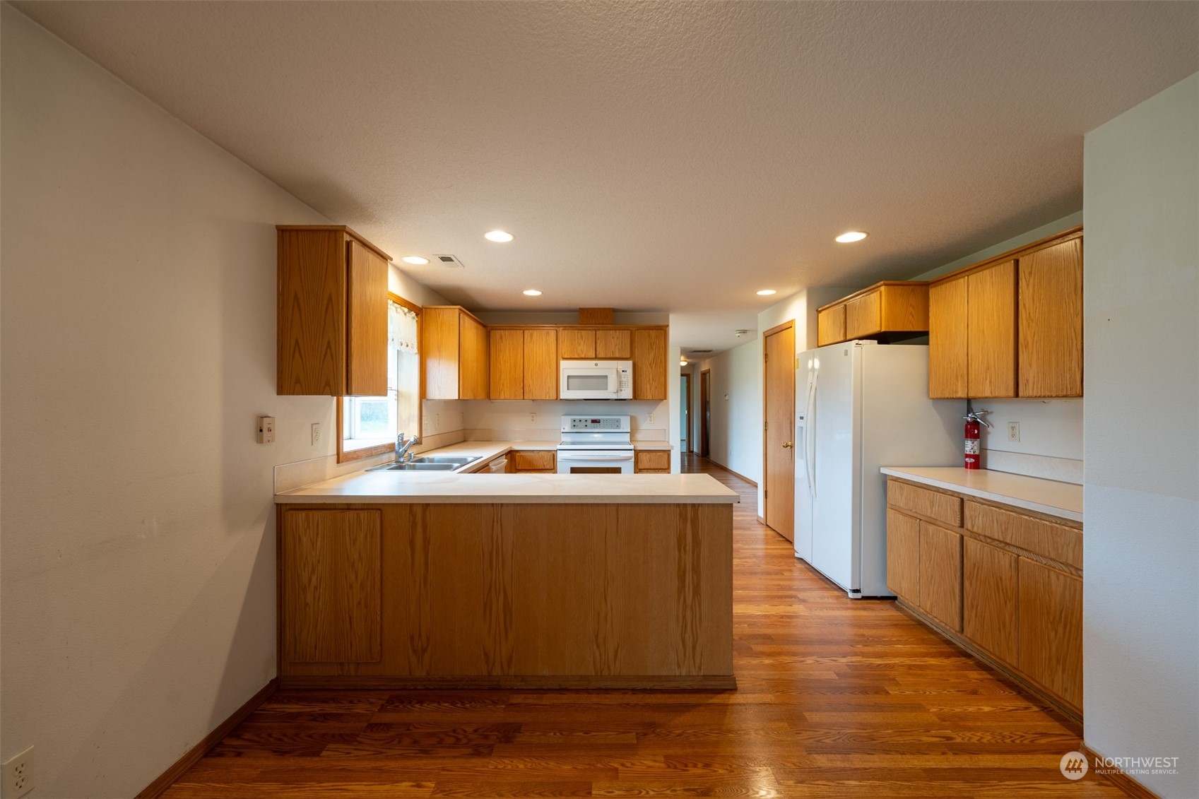 444 Bond Road Castle Rock, WA 98611 - Photo 13 of 40 a living room with stainless steel appliances granite countertop a refrigerator a sink dishwasher and a stove with wooden floor