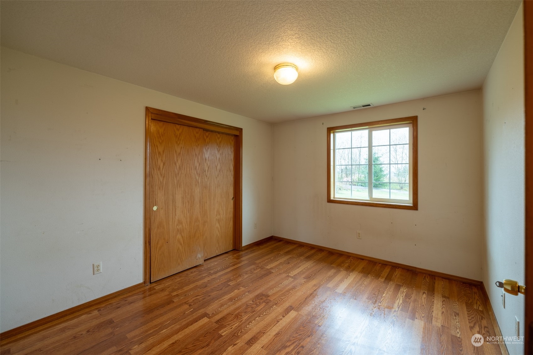 444 Bond Road Castle Rock, WA 98611 - Photo 19 of 40 an empty room with wooden floor and windows