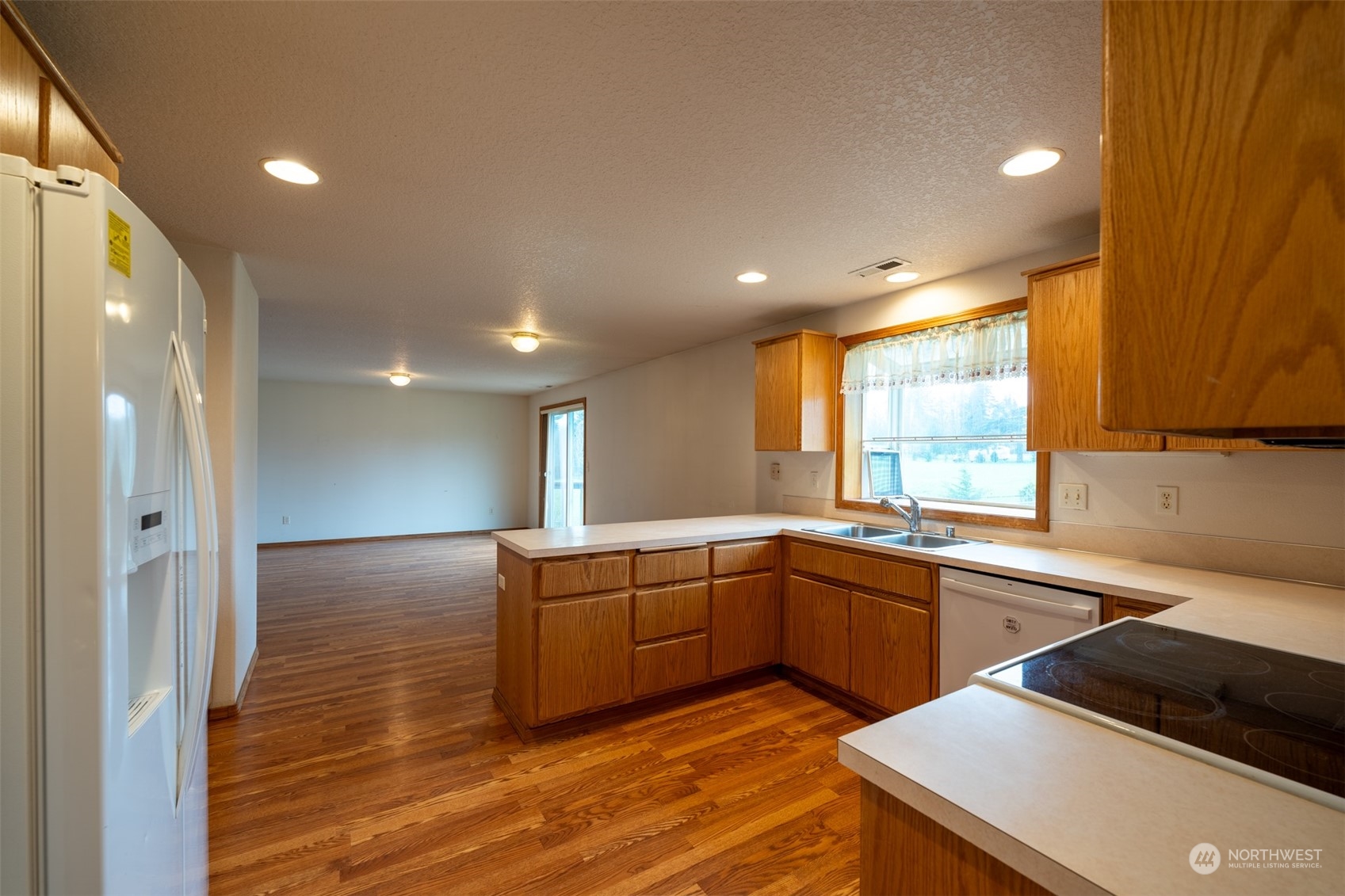 444 Bond Road Castle Rock, WA 98611 - Photo 9 of 40 a large kitchen with stainless steel appliances granite countertop a sink and cabinets with wooden floor