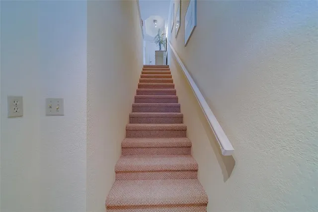 a view of a hallway with wooden floor and cabinet