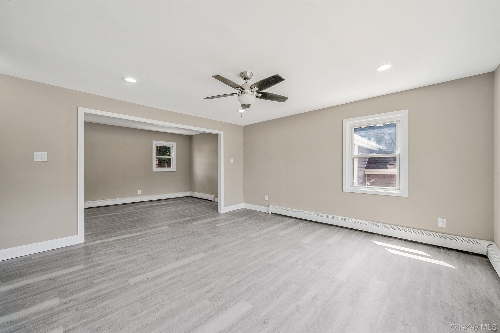 286 Old Country Road Deer Park, NY 11729 - Photo 11 of 33 an empty room with wooden floor and windows
