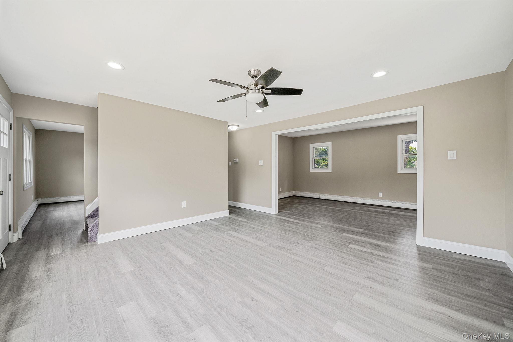 286 Old Country Road Deer Park, NY 11729 - Photo 12 of 33 an empty room with wooden floor and chandelier fan