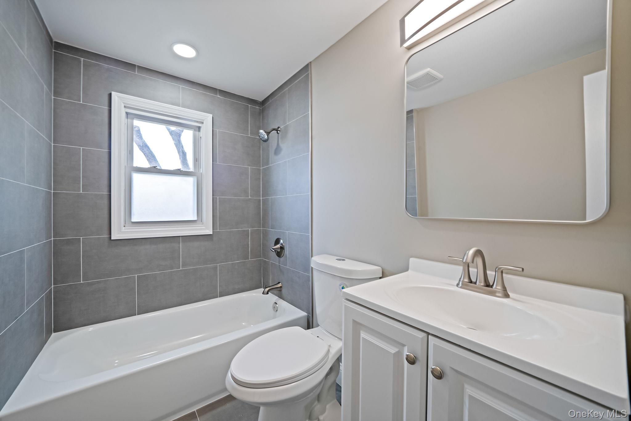 286 Old Country Road Deer Park, NY 11729 - Photo 15 of 33 a bathroom with a sink toilet a bathtub and shower