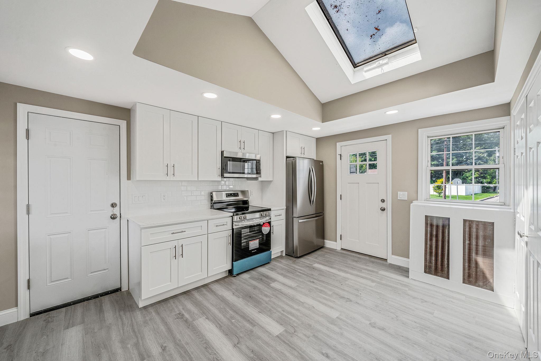 286 Old Country Road Deer Park, NY 11729 - Photo 8 of 33 a kitchen with stainless steel appliances granite countertop a refrigerator a stove and a wooden floors