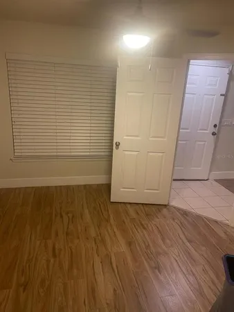 an empty room with wooden floor and white walls
