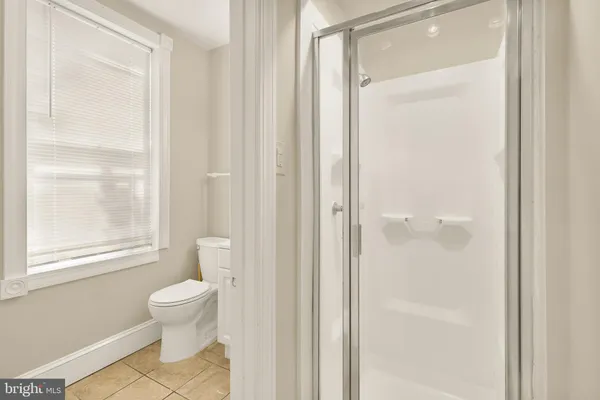 a bathroom with a toilet shower and a window