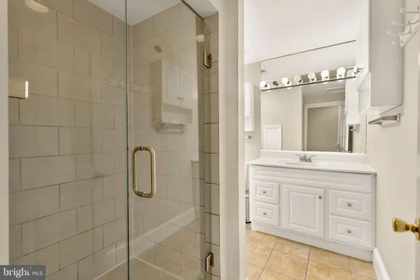 a bathroom with a granite countertop sink a mirror and a shower