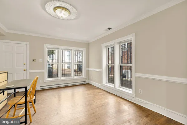 a view of an empty room with a window and wooden floor