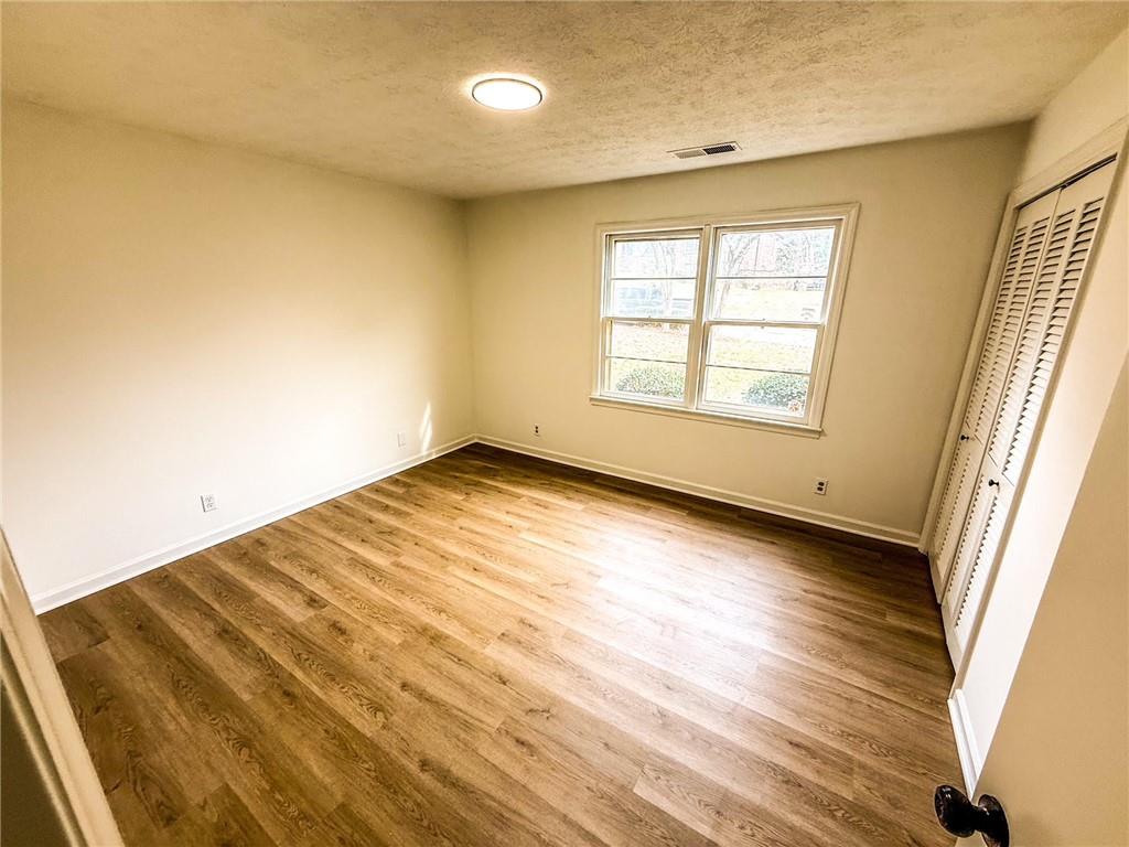 6485 Carolyn Court Rex, GA 30273 - Photo 6 of 12 an empty room with wooden floor and windows