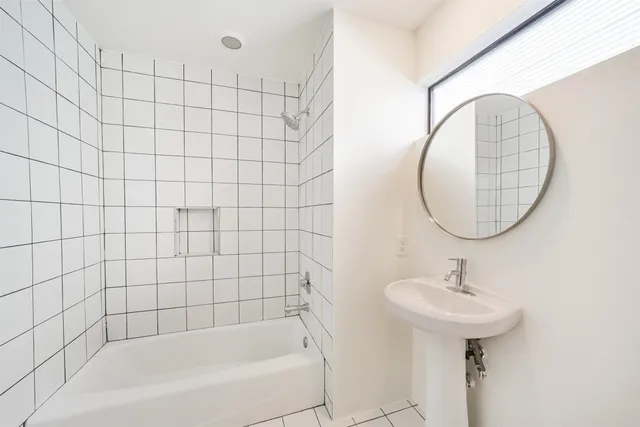 a bathroom with a sink a mirror and a bathtub