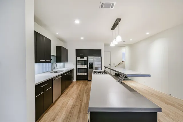 a kitchen with kitchen island a sink appliances and a counter top space