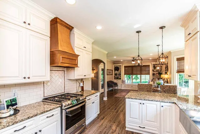 a kitchen with stainless steel appliances granite countertop a stove a sink and a wooden cabinets