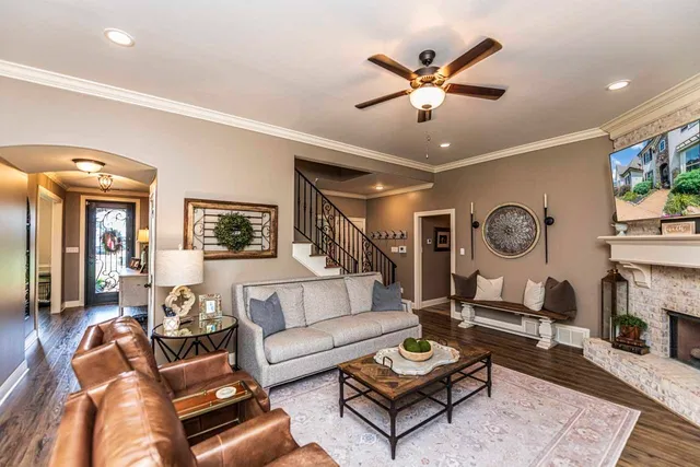 a living room with furniture a clock and a ceiling fan