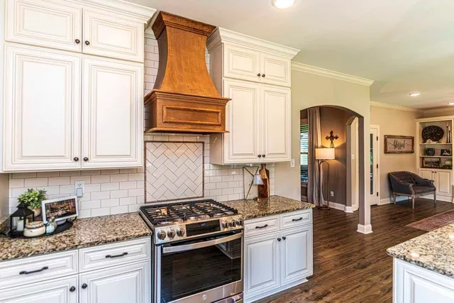 a kitchen with stainless steel appliances granite countertop a stove a sink and cabinets