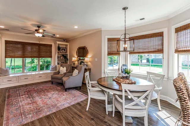 a living room with furniture a ceiling fan and a large window