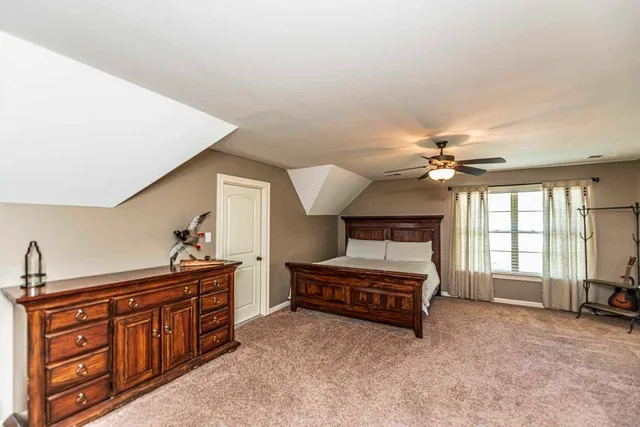 a spacious bedroom with a bed and a chandelier