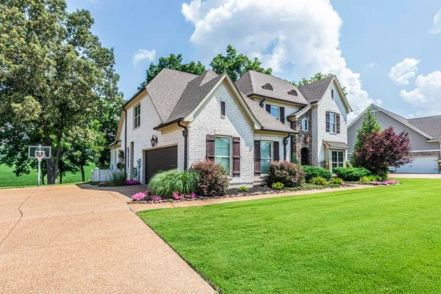 a front view of a house with a garden and plants