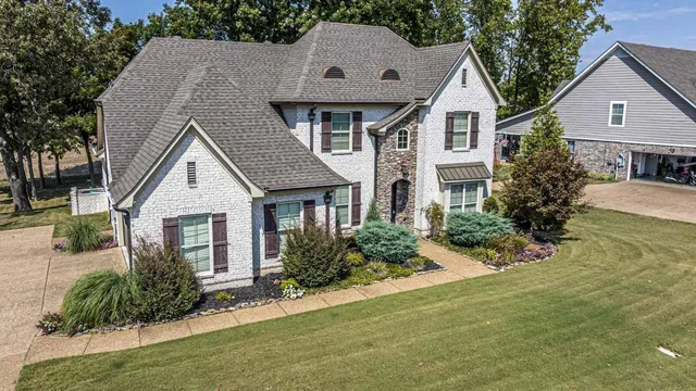 a front view of a house with a yard and potted plants