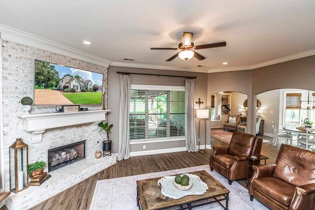 a living room with furniture a fireplace and a floor to ceiling window