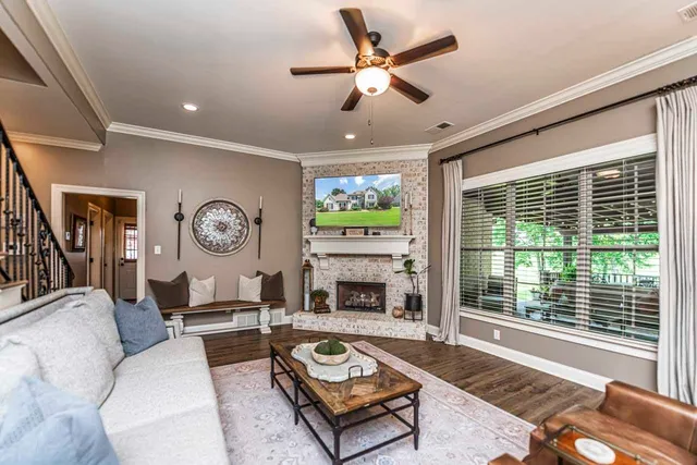 a living room with furniture a fireplace and a large window