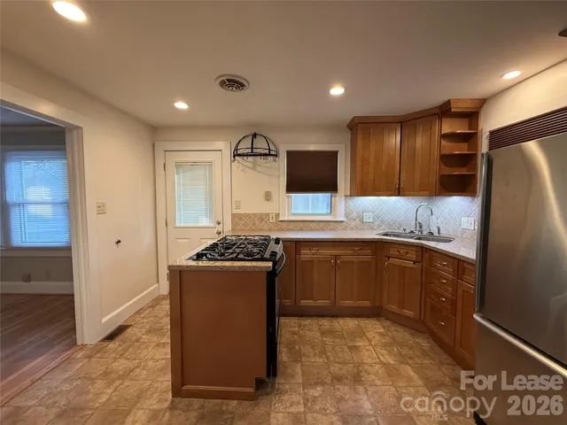 a kitchen with stainless steel appliances granite countertop a refrigerator stove and sink