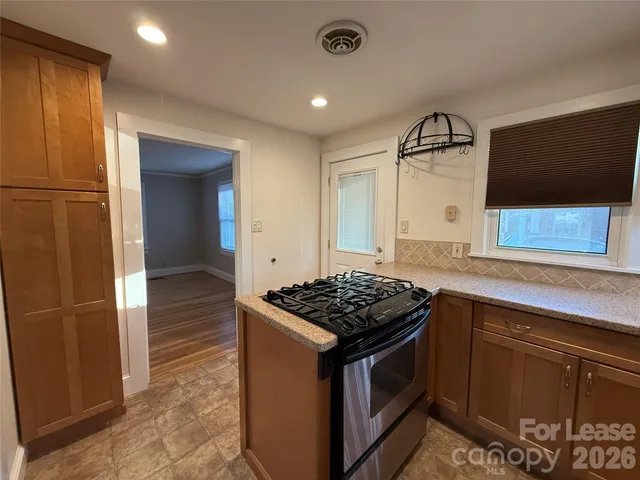 a kitchen with stainless steel appliances granite countertop a stove a sink and a refrigerator