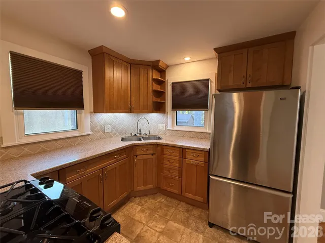 a kitchen with stainless steel appliances granite countertop a refrigerator and a sink