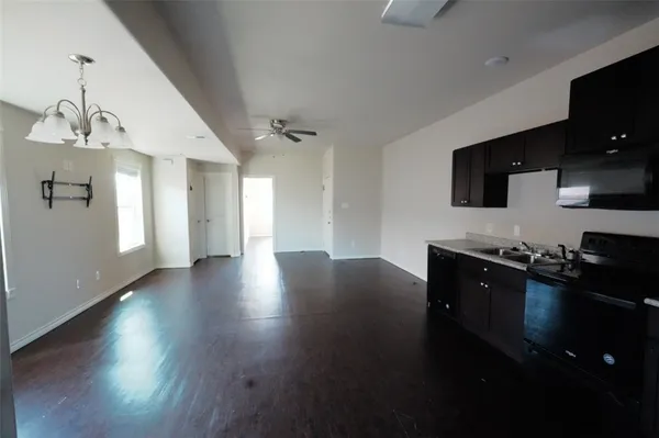 a kitchen with granite countertop a stove and a wooden floor