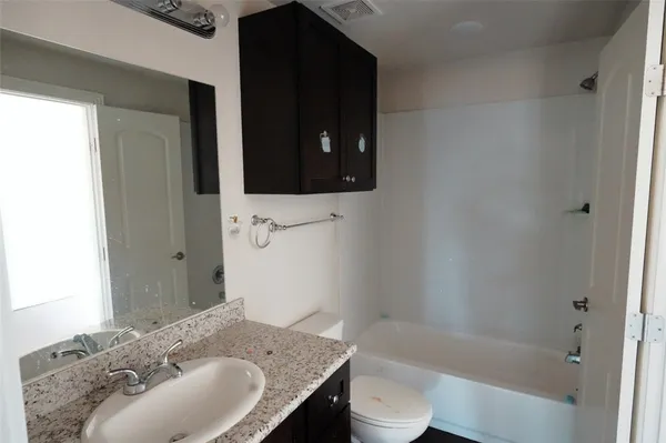 a bathroom with a granite countertop sink and a bathtub