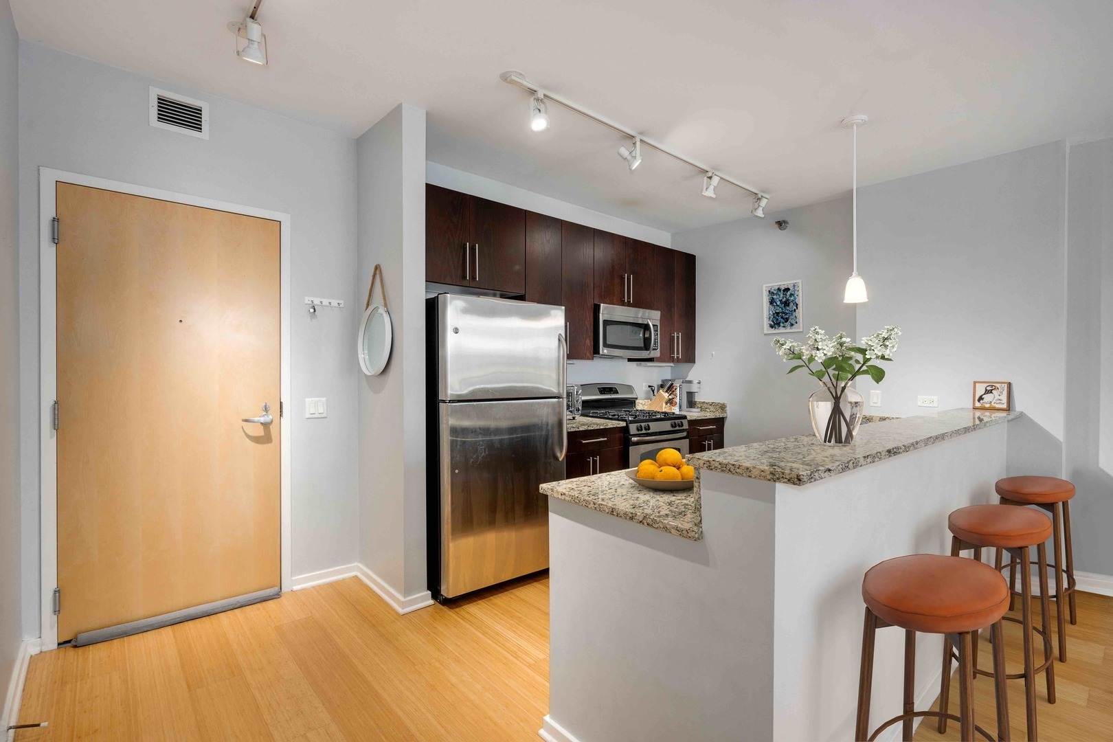 123 South Green Street, Unit 710B Chicago, IL 60607 - Photo 8 of 17 a kitchen with stainless steel appliances kitchen island granite countertop a refrigerator and a sink