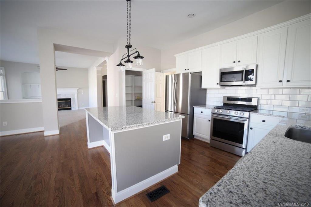 3225 Colonel Springs Way Fort Mill, SC 29708 - Photo 4 of 6 a kitchen with stainless steel appliances granite countertop a refrigerator a stove a sink dishwasher and a stove with wooden floor