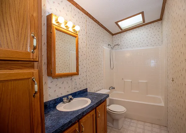 a bathroom with a granite countertop sink toilet and shower