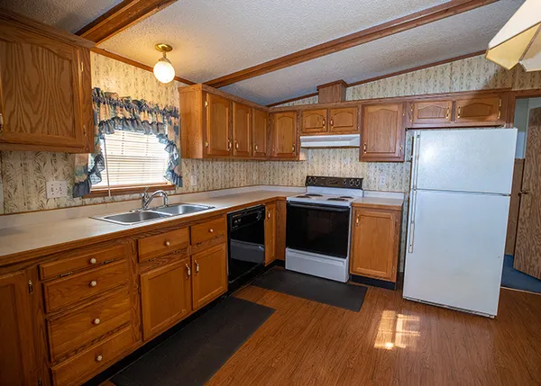 a kitchen with stainless steel appliances granite countertop a refrigerator a sink dishwasher a stove and a microwave oven on dining table with wooden floor