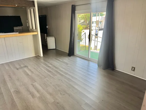 a view of a kitchen with wooden floor and a sink