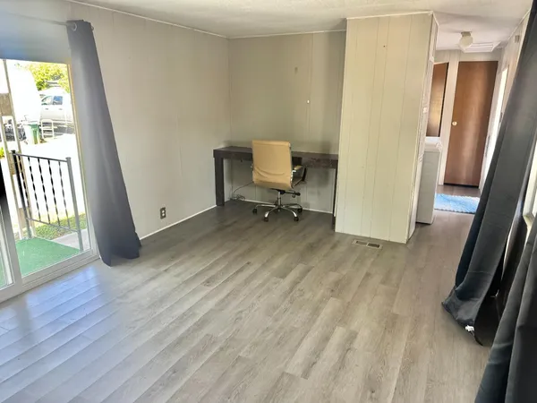a view of a room with wooden floor and a window