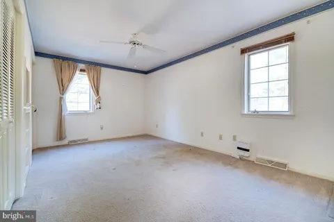a view of deck with table and chairs under wooden roof with potted plants