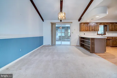 a view of a hallway with kitchen and chandelier